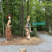 zwei Figuren aus Holz im Wald