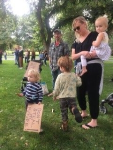 eine Frau und ein Mann mit 3 Kindern, das Kleinste hat ein Schild in der Hand zum Thema Nachhaltigkeit