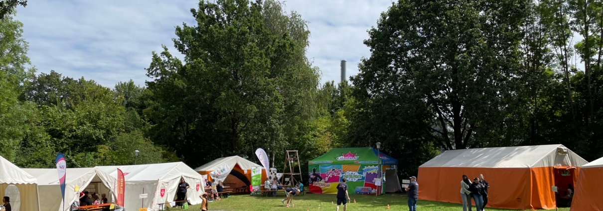 ein Platz auf einer Wiese mit Zelten